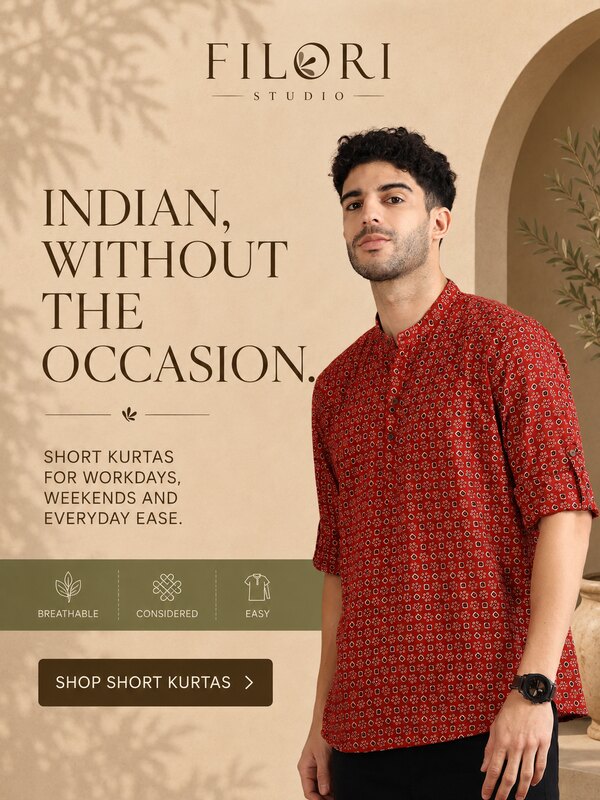 Model wearing a red Filori Studio short kurta in a warm architectural setting for everyday wear.